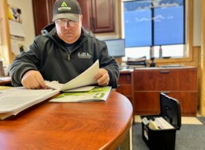 Craig Schaunaman sifts through his well-organized file of paperwork about the carbon pipeline proposal. South Dakota Searchlight photo by Joshua Haiar