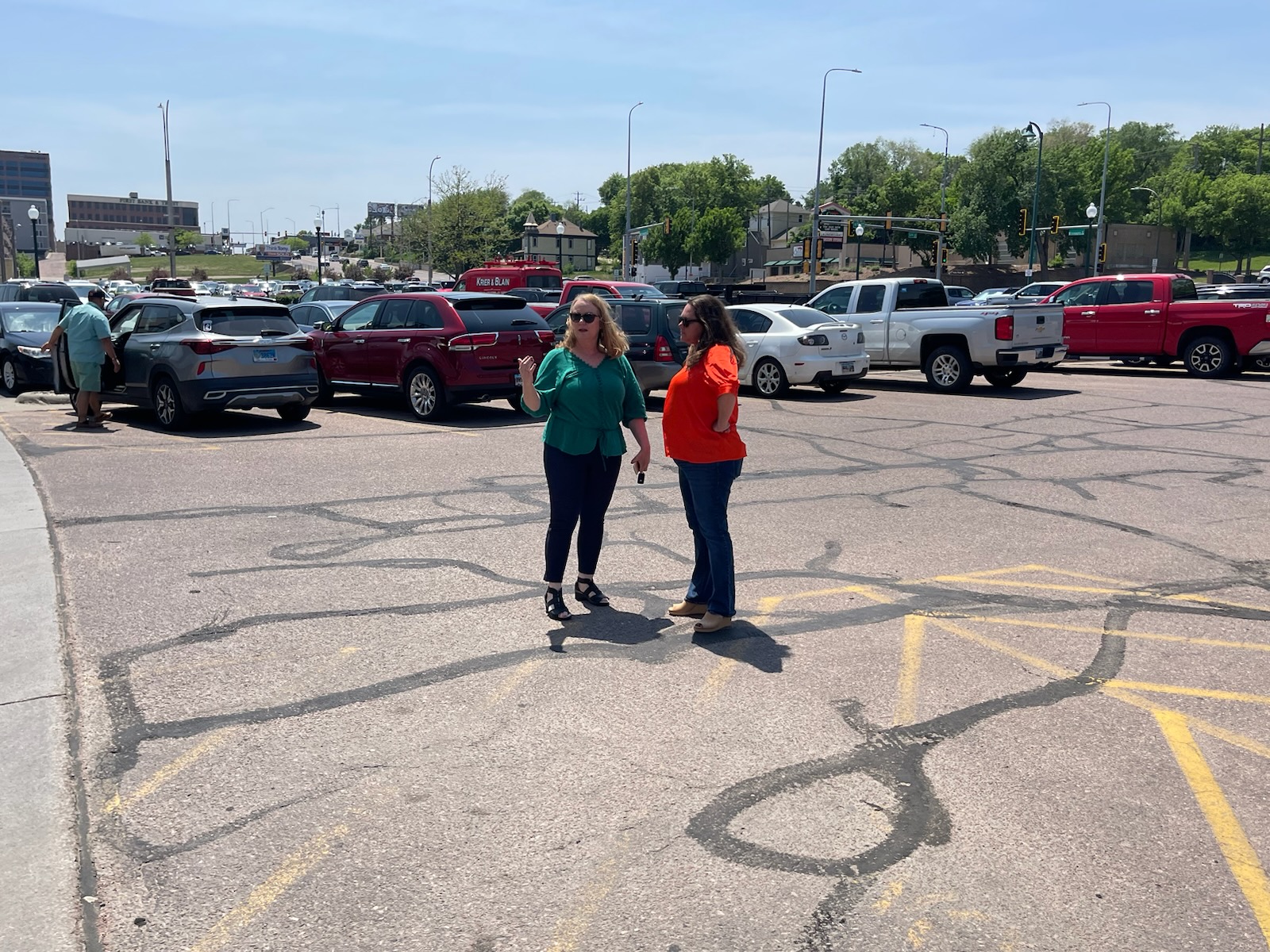 Pam Cole, left, and Tiffany Campbell of Dakotans for Health discuss petition circulation strategy on the edge of the designated area recently assigned by the Minnehaha County Commission. South Dakota News Watch photo by Stu Whitney