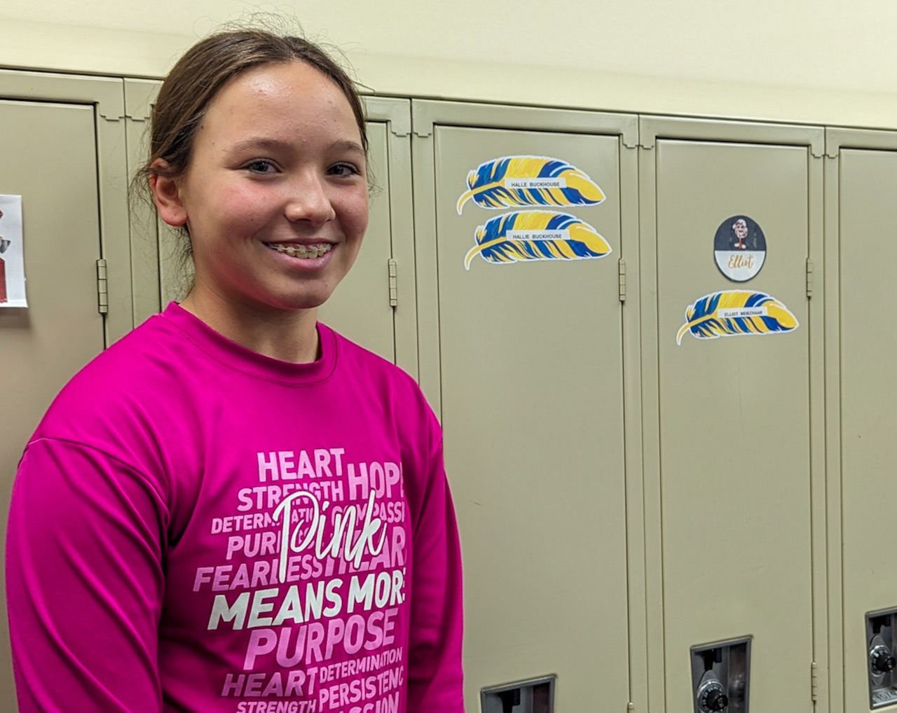 Holgate Middle School Student Council President Anniston Bindenagel stands near lockers with feathers from Holgate's new Eagle Feather Project. Courtesy photo from Aberdeen Public School District