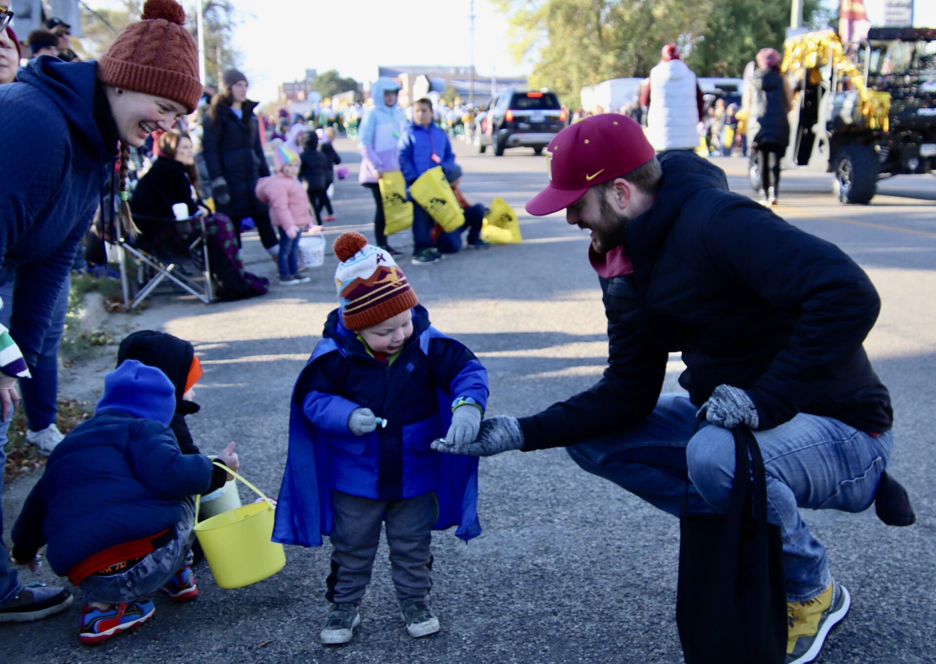 Tyler Oliver hands out candy to a child attending the 2023 Northern State University homecoming parade on Saturday, Oct. 7. Aberdeen Insider photo by Scott Waltman