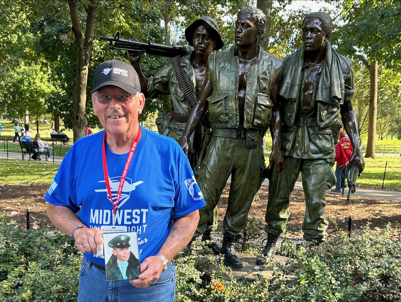 Dave Rogers, posing with a photo from his time in the military, saw a variety of memorials through the Midwest Honor Flight. Courtesy photo